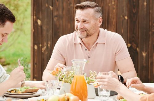 A cheerful family enjoying an outdoor meal together in a warm setting.